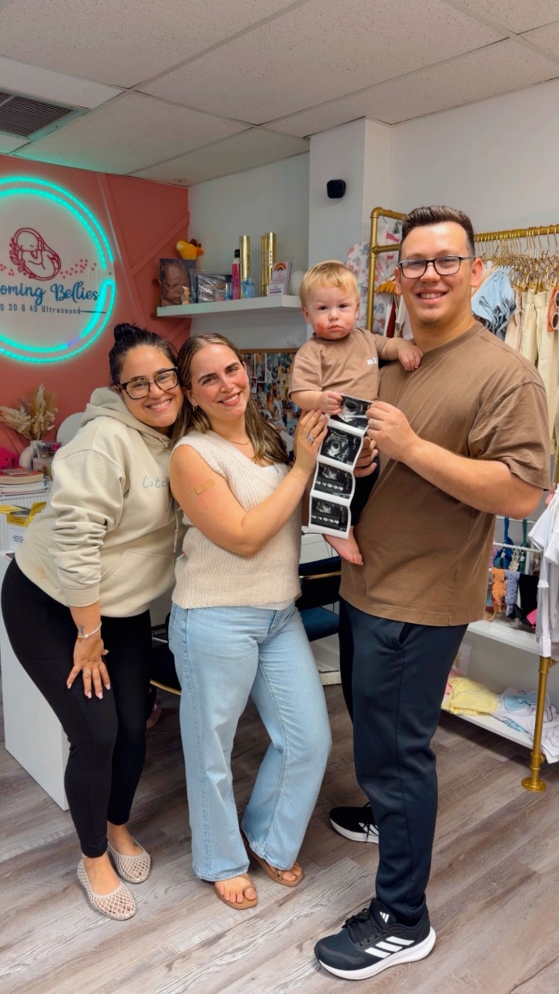 A family celebrating their ultrasound photos with their doula at the Blooming Bellies studio
