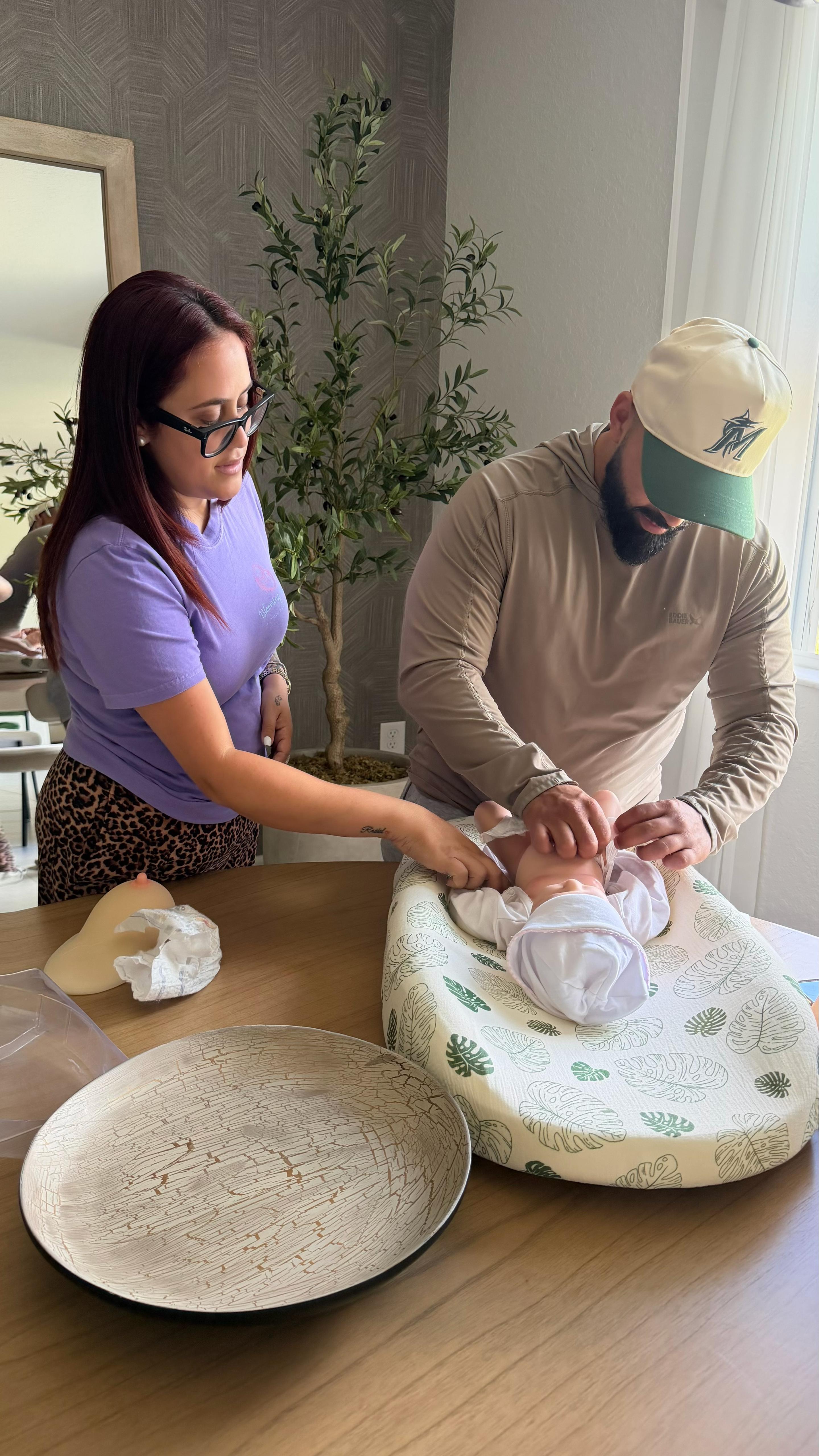 Parents practicing newborn care during a class at Blooming Bellies