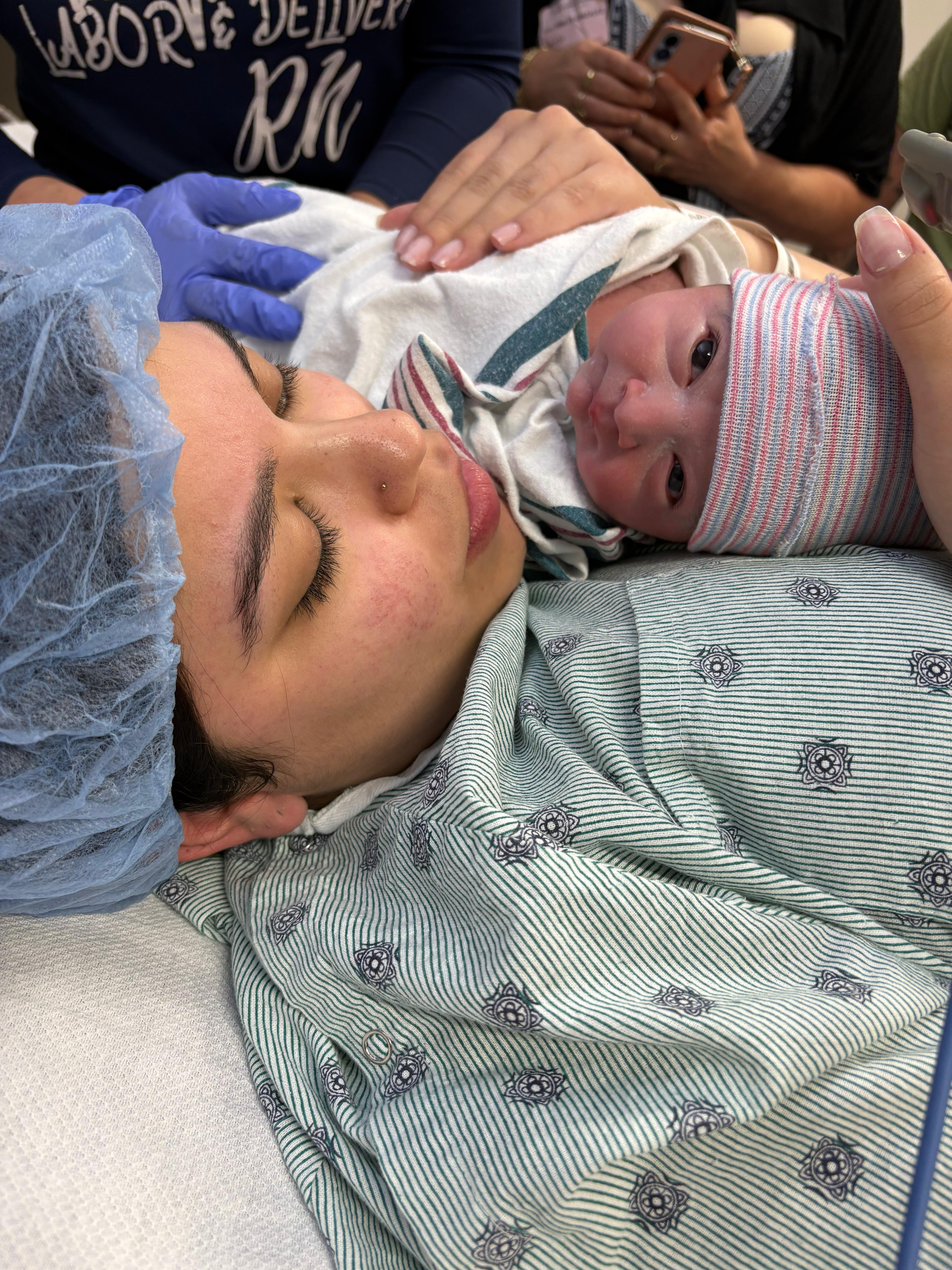 A mother resting skin-to-skin with her newborn right after delivery