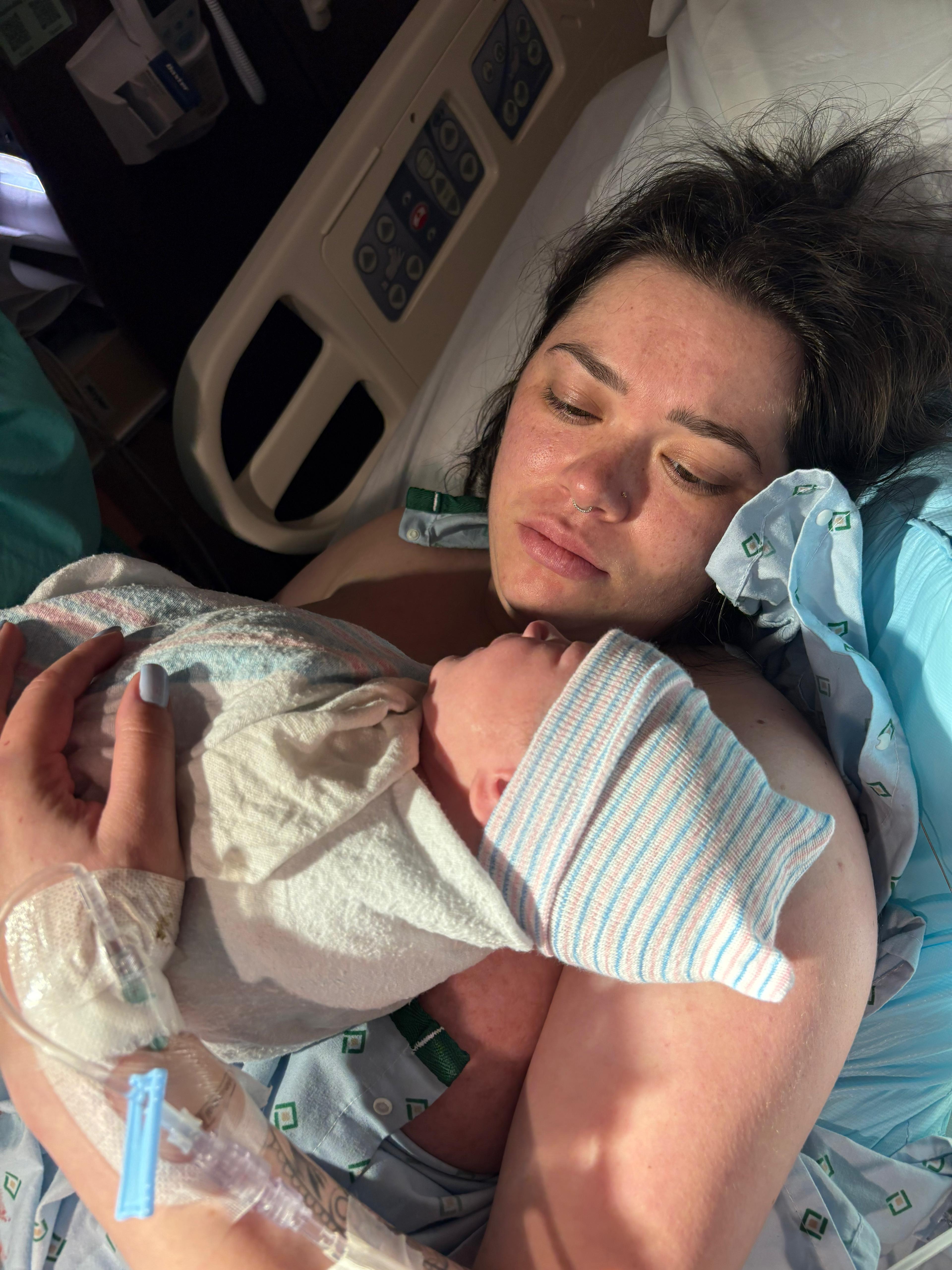 A mother holding her newborn close after giving birth
